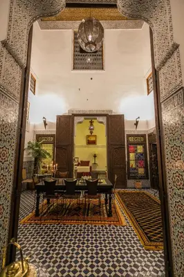 a dining room with a table and chairs in a room at La Cheminée Bleue Fes in Fès