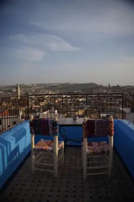 a table and two chairs sitting on top of a balcony at La Cheminée Bleue Fes in Fès