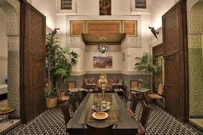 a dining room with a table and chairs at La Cheminée Bleue Fes in Fès