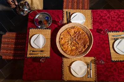 a table with plates and utensils on a red table cloth at Kasbah Hotel Ziz Palace Rissani in Rissani