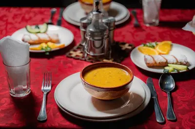 a table with plates of food and a bowl of soup at Kasbah Hotel Ziz Palace Rissani in Rissani