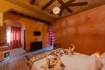 a bedroom with a bed and a tv in a room at Kasbah Hotel Ziz Palace Rissani in Rissani