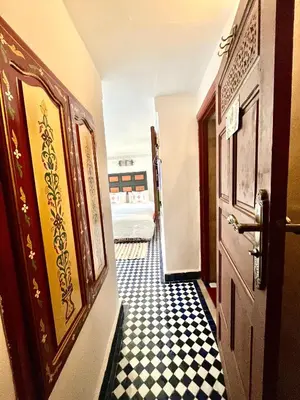 a hallway with a door and a black and white checkered floor at Dar atlas in Fès