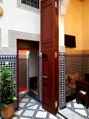 a living room with a fireplace in a house at Dar atlas in Fès