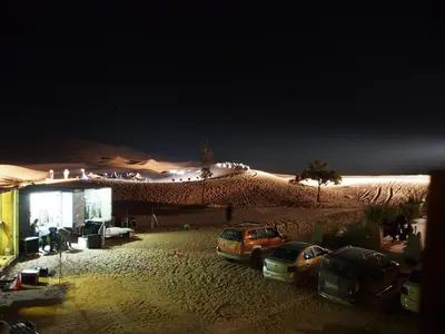 a group of cars parked in the desert at night at Kasbah Erg Chebbi in Merzouga