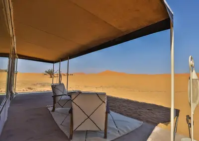 a chair sitting under a tent in the desert at Aiour Luxury Camp in Merzouga