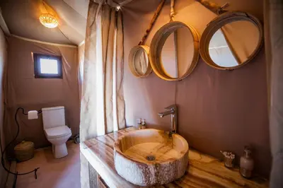 a bathroom with a large wooden sink and mirrors at Aiour Luxury Camp in Merzouga