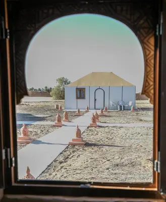 a view through a window of a building on the beach at Aiour Luxury Camp in Merzouga