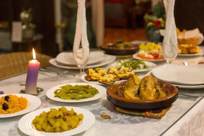 a table topped with plates of food and a candle at Riad Dar Cordoba in Fès