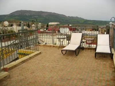 a patio with two chairs and a table and a fence at Riad Dar Cordoba in Fès