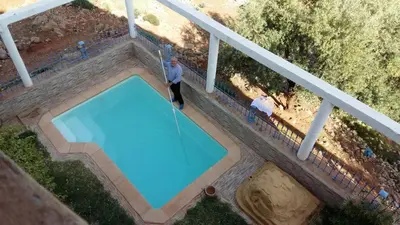 a man is playing golf next to a swimming pool at Tigmi Dar Samy in Bine el Ouidane