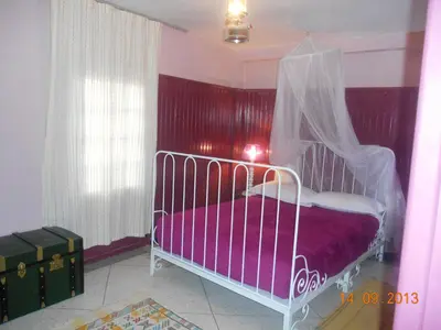a bedroom with a white bed with a canopy at Tigmi Dar Samy in Bine el Ouidane