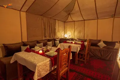 a dining room with tables and chairs in a tent at Sirocco Luxury Camp in Merzouga