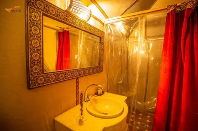 a bathroom with a sink and a mirror and a toilet at Sirocco Luxury Camp in Merzouga