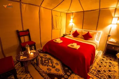 a bedroom with a red bed in a tent at Sirocco Luxury Camp in Merzouga