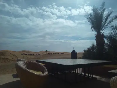 a table and chairs in the middle of the desert at Sahara Desert Camp in Hassilabied
