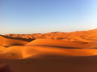 a group of sand dunes in the desert at Sahara Desert Camp in Hassilabied
