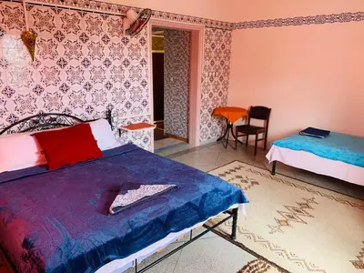a bedroom with a bed and a table and a chair at Riad iriki in Tinerhir