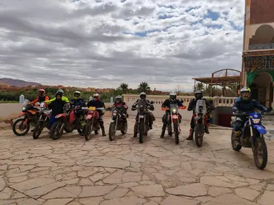 a group of people on motorcycles parked in front of a building at Riad iriki in Tinerhir