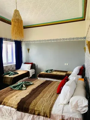 a bedroom with two beds and a window at Riad iriki in Tinerhir