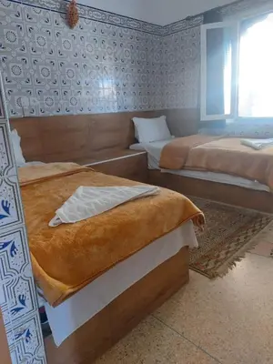 a bedroom with two beds and a window at Riad iriki in Tinerhir