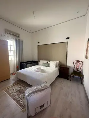 a bedroom with a large bed and a suitcase on the floor at Maison d'hôtes La Ferme AZIZA in Fès