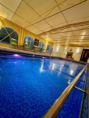 a large swimming pool with blue water at Maison d'hôtes La Ferme AZIZA in Fès