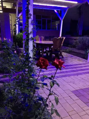 a patio with a table and chairs at night at Maison Duffal in Azrou