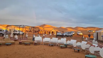 a group of chairs and tables in the desert at Desert camp camel & sandboarding in Merzouga