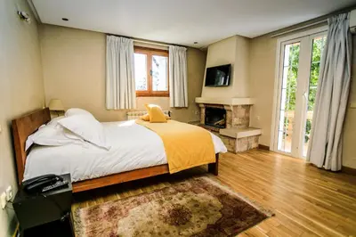 a bedroom with a large bed and a fireplace at Le Palais des Cerisiers in Azrou