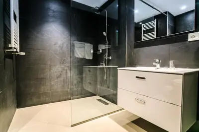 a bathroom with a glass shower and a sink at Le Palais des Cerisiers in Azrou