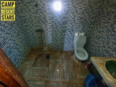 a bathroom with a toilet and a sink in it at Camp Desert Stars in Mhamid