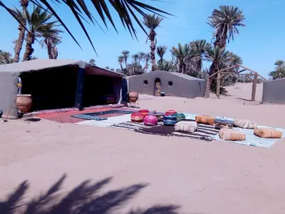 a group of bowls on a blanket in the desert at Camp Desert Stars in Mhamid