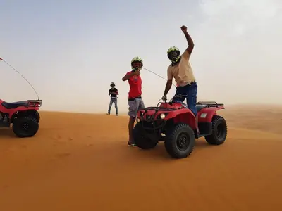 two people standing on a wheeler in the desert at Camp Desert Stars in Mhamid