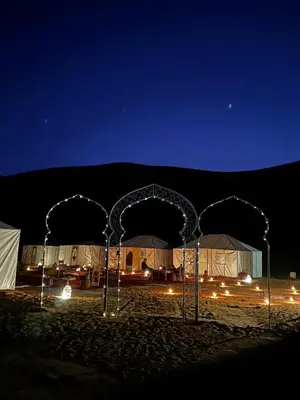 a group of tents in the desert at night at Camp atlantic chegaga in Mhamid