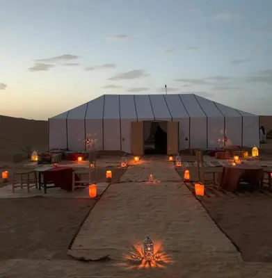 a tent in the middle of the desert with candles at Camp atlantic chegaga in Mhamid