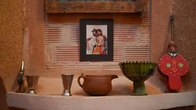 a shelf with vases and a picture on a wall at Dar Mouna in Aït Ben Haddou