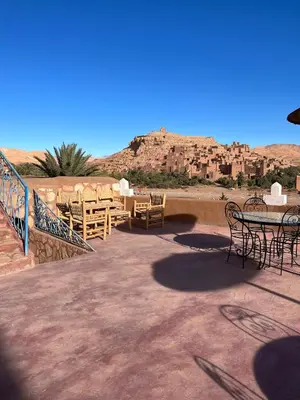 a patio with tables and chairs in the desert at Dar Mouna in Aït Ben Haddou