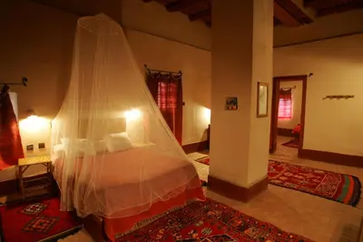 a bedroom with a bed with a mosquito net at Gite Elkhorbat in Tinejdad