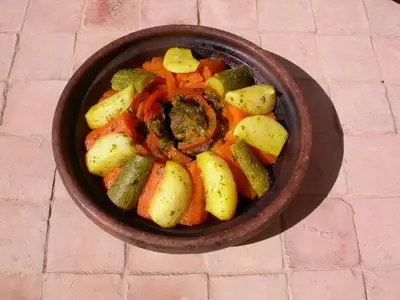 a bowl of food with potatoes and vegetables on a table at Gite Elkhorbat in Tinejdad