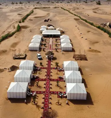 an aerial view of a group of white tents in the desert at Hotel Riad Ali in Merzouga
