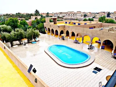 a large swimming pool in the middle of a building at Hotel Riad Ali in Merzouga