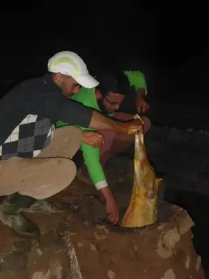 two men are looking at a large object on the ground at Gîte Baraka Taghia in Taghia