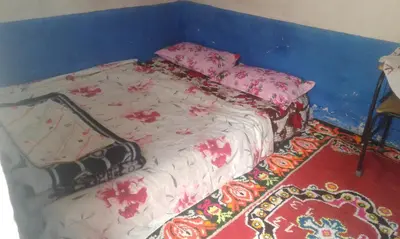 a bed in a room with a blue wall at Gîte Baraka Taghia in Taghia