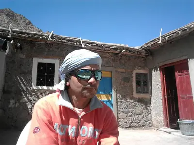 a man wearing a turban standing in front of a house at Gîte Baraka Taghia in Taghia
