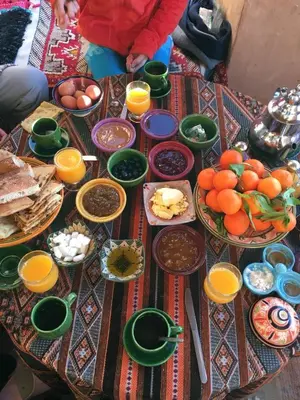 a table with plates of food and bowls of food at Kasbah Maktob Tamnougalt in Agdz