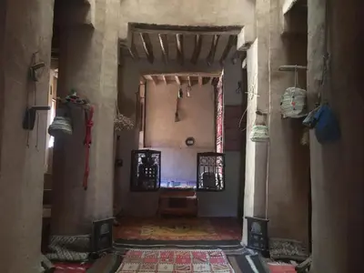 a hallway of a building with a room with a table at Kasbah Maktob Tamnougalt in Agdz