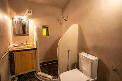 a bathroom with a white toilet and a sink at Riad Hidaya in Fès