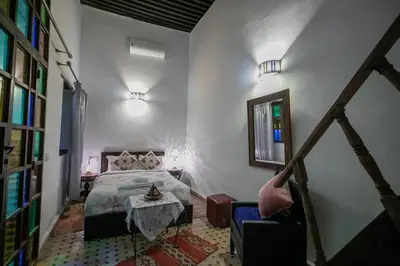 a bedroom with a bed and a table in it at Riad Hidaya in Fès