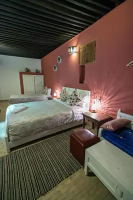 a bedroom with two beds and a table with lamps at Riad Hidaya in Fès